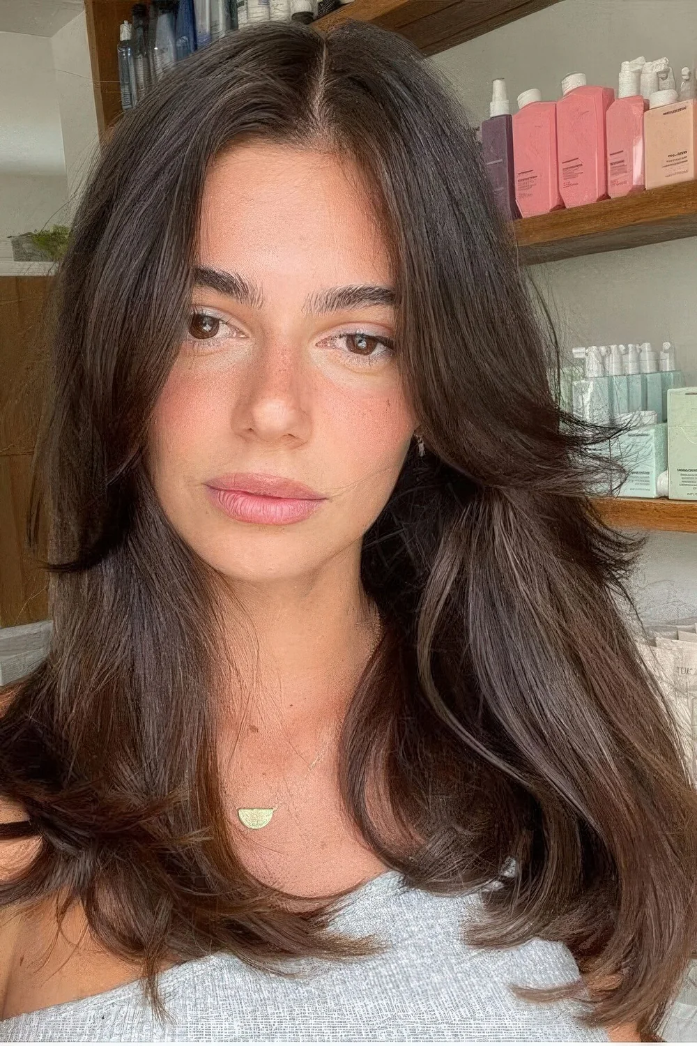 Long dark brown hair with curtain bangs and center part.