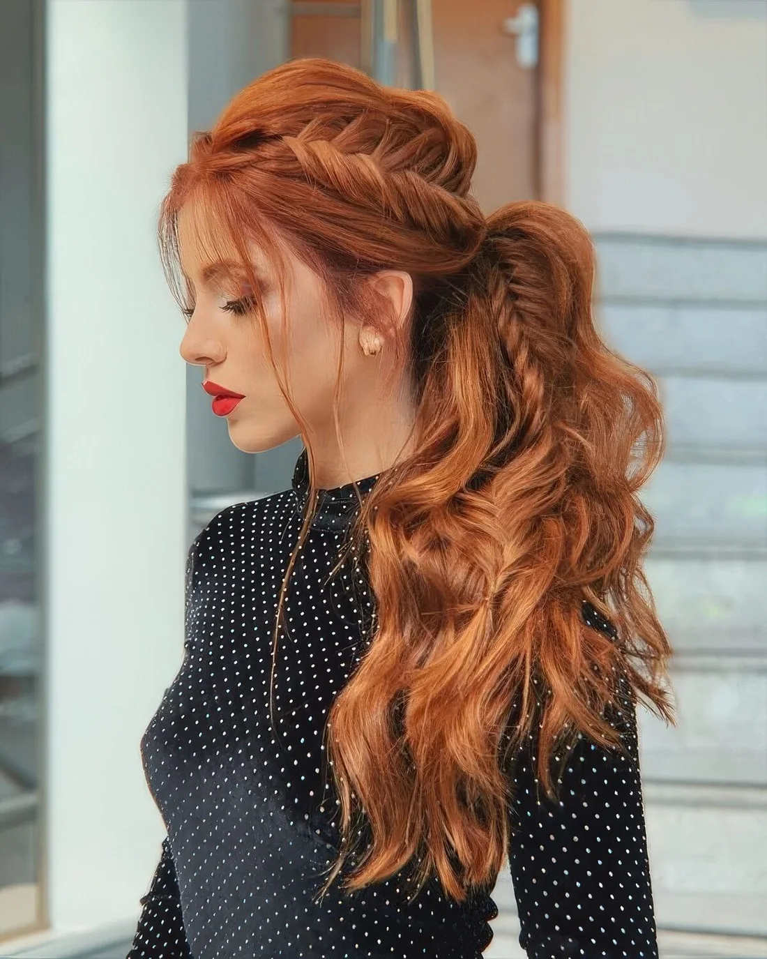 Low ponytail with a voluminous fishtail braid long the whole head and in the ponytail, with a messy volume on top.