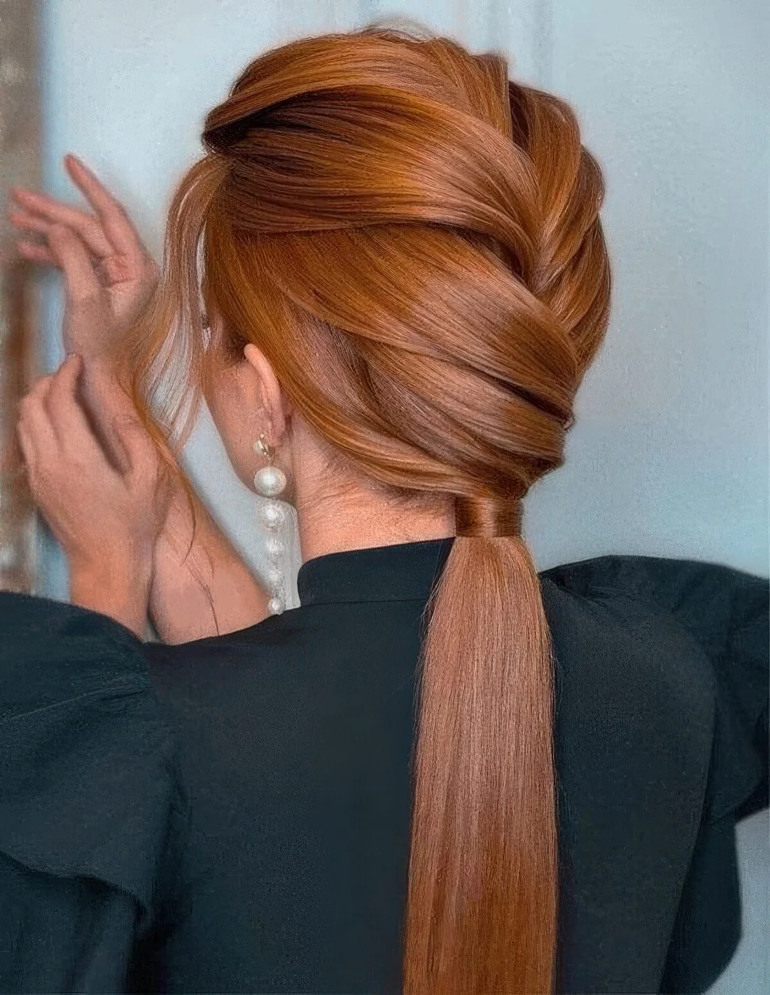 Chic low ponytail with a voluminous braided top and some waves down.
