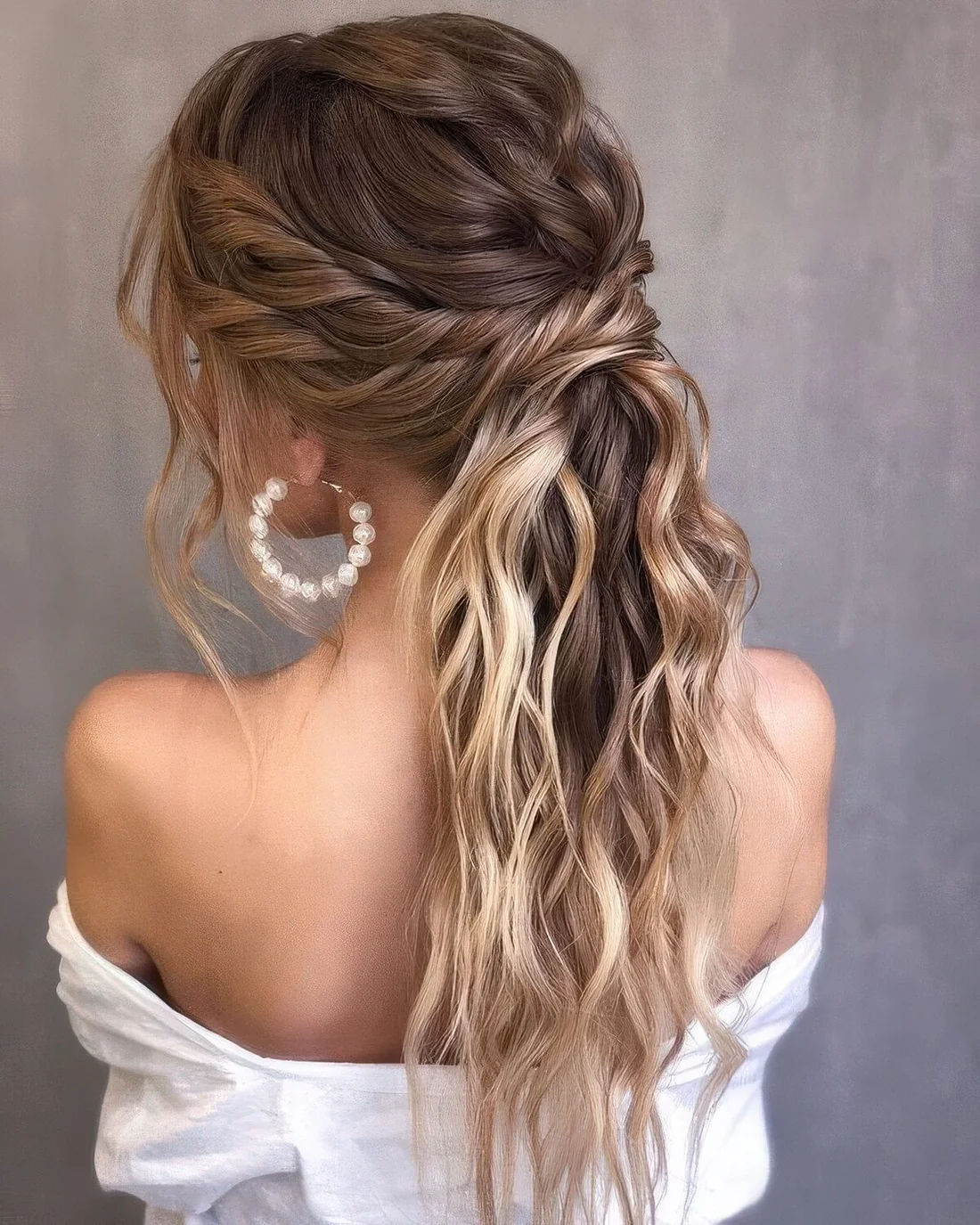Chic and lovely half updo with a braided and wavy top and twists wrapping the head, waves down.