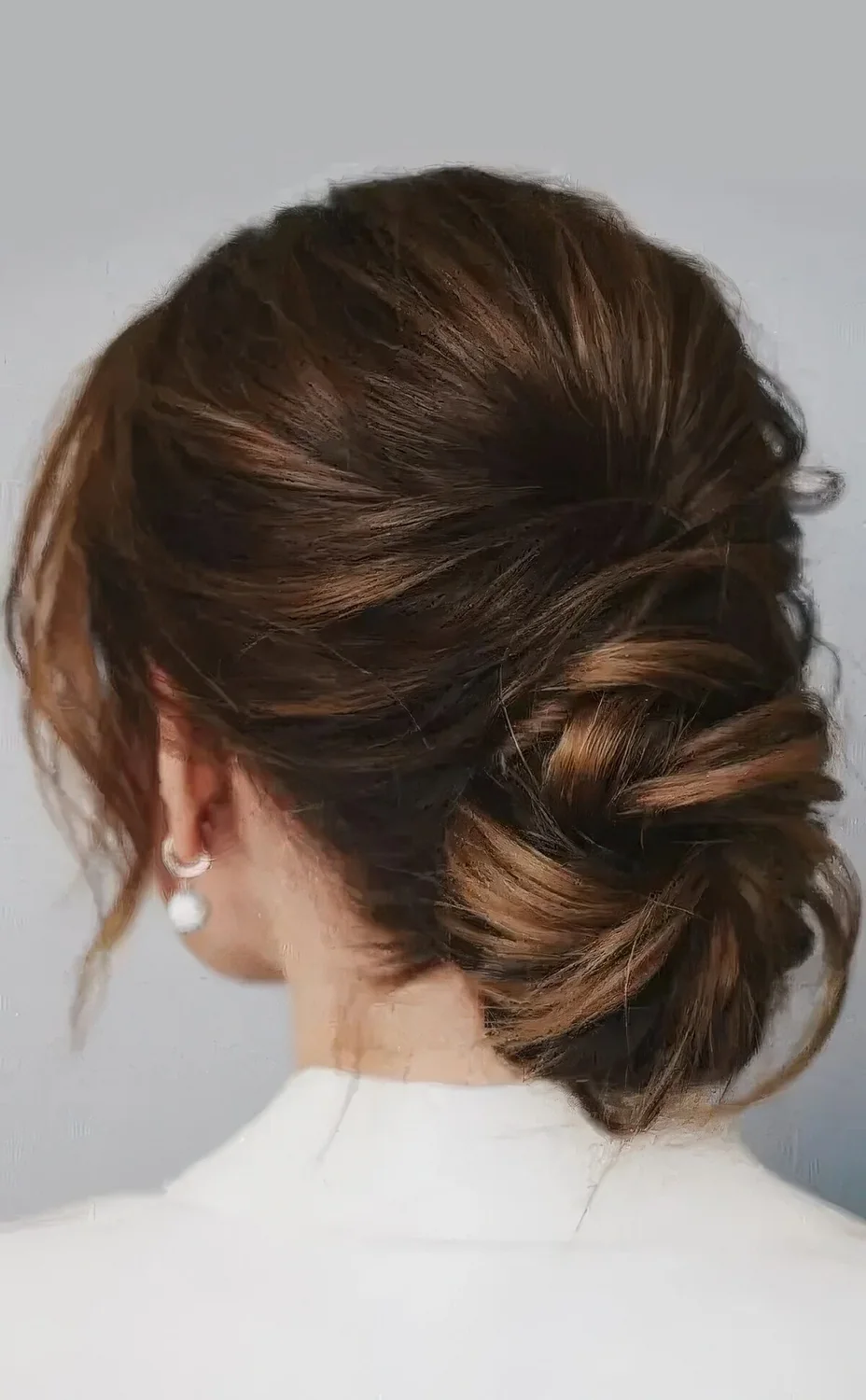 Chic low ballerina bun with a bump on top and face-framing locks.