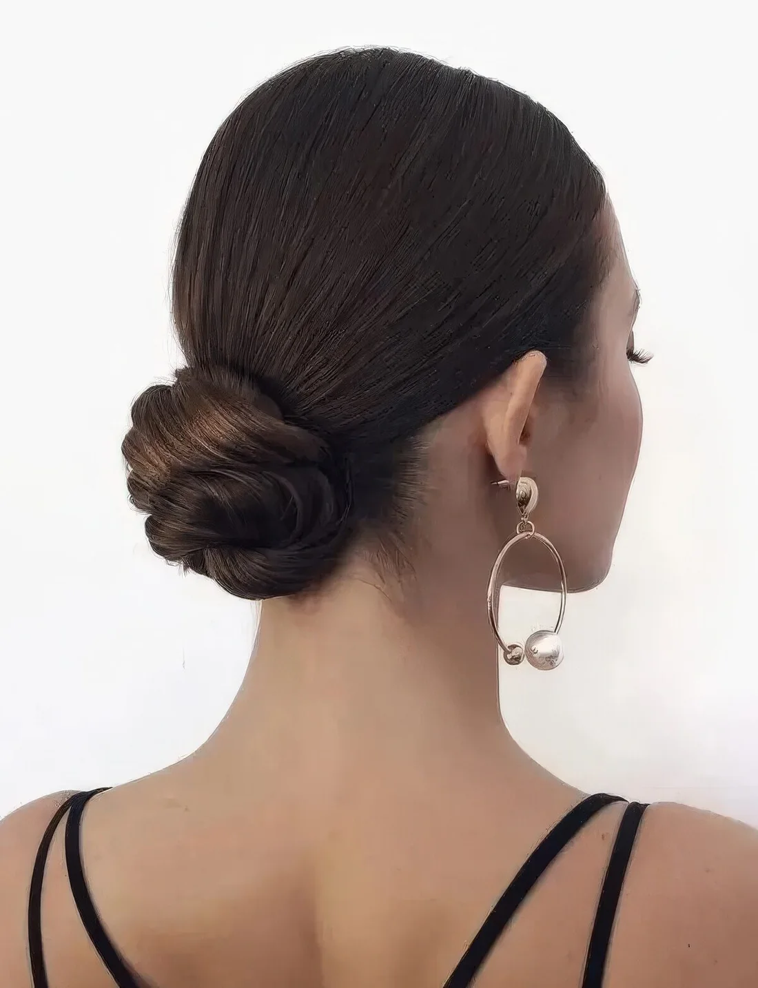 Formal wedding updo with a twisted low bun and a sleek top.