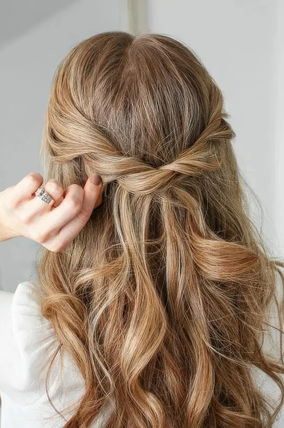 Half updo with a twisted braid and waves down.