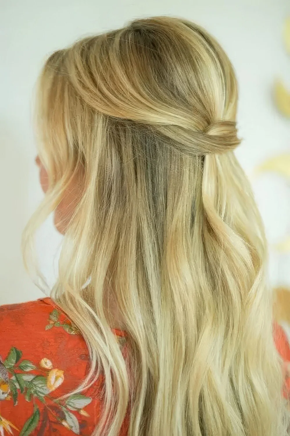 Fast and minimal half updo with a bump, a twisted touch and straight hair down plus waves around the face.