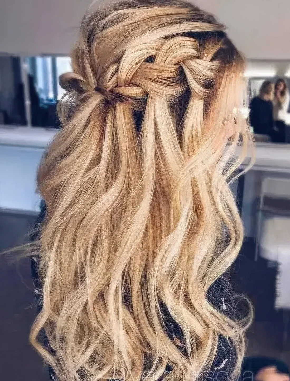 Long wavy half updo hairstyle with a braided halo and locks down for a boho feel.