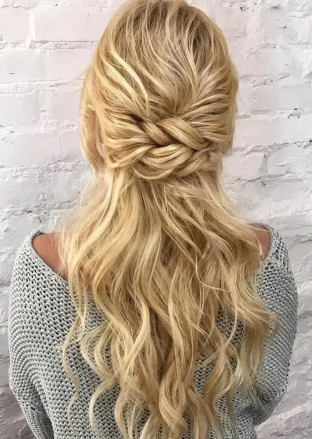 Eye catchy half updo with a bump on top and a double twisted element, some waves down.