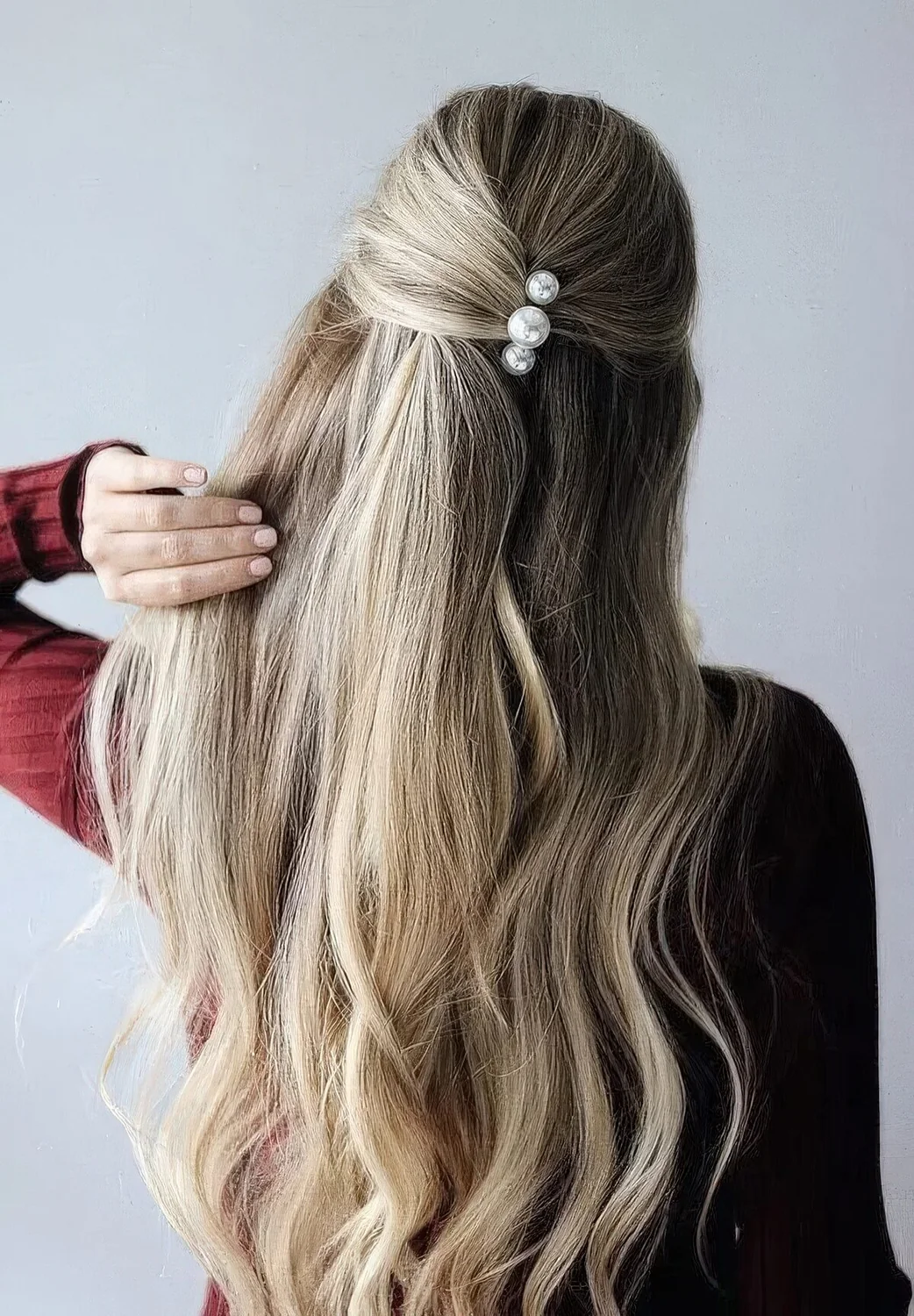 Simple and cool half updo with hair pulled off the face, with pearl hairpins and hair down.
