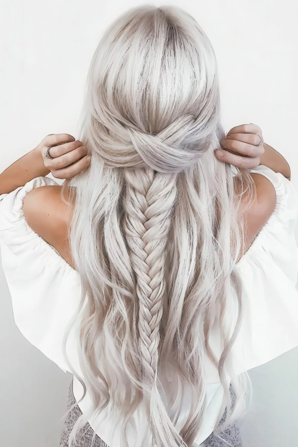 Half updo with waves, a thick braid and a twisted element.