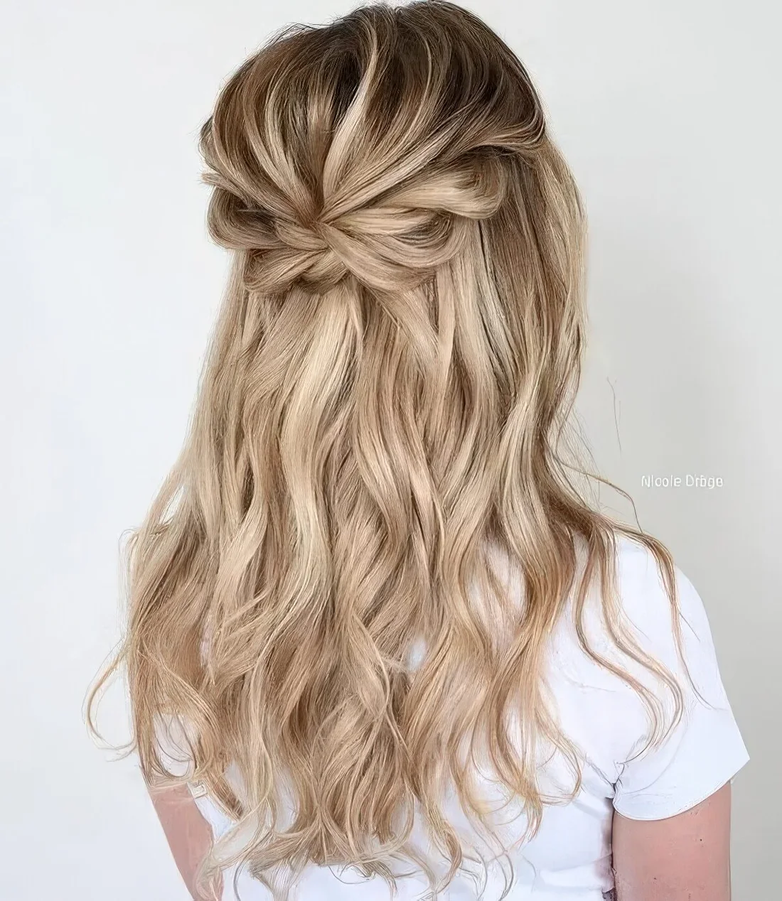 Boho half updo with a dimensional bump, a loose braided halo and waves down.