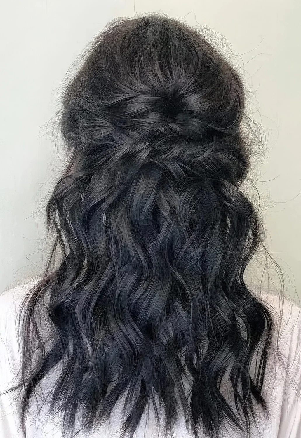 Messy and textured half updo with a bump on top, a twisted touch and waves down.