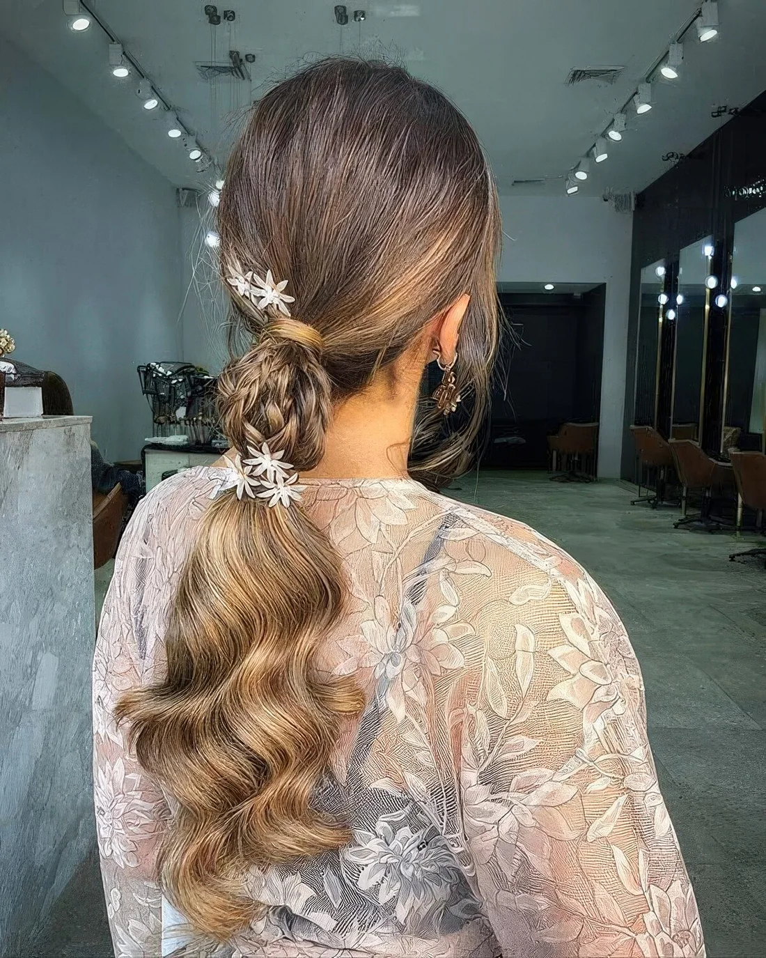 Creative Christmas ponytail with braids and floral haiir pins and waves down.