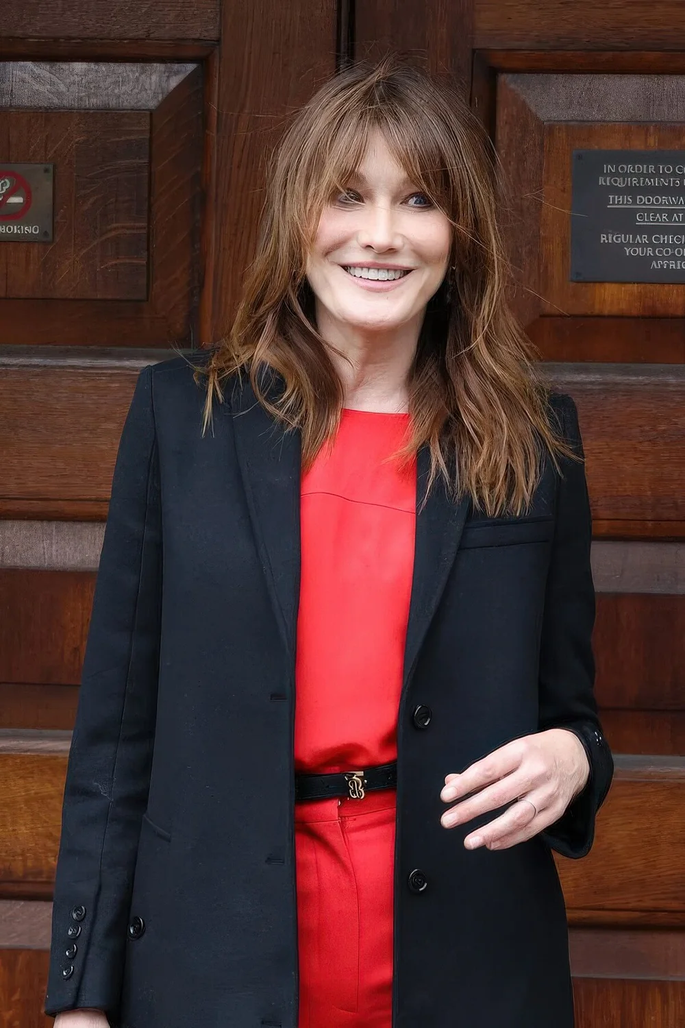 Carla Bruni rocking long brunette hair with caramel highlights and bottleneck bangs.