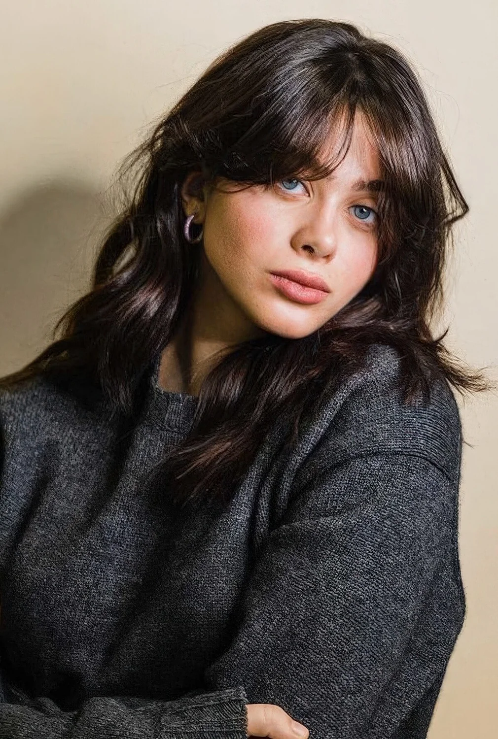 Long dark chestnut hair with waves and texture plus bottleneck bangs.