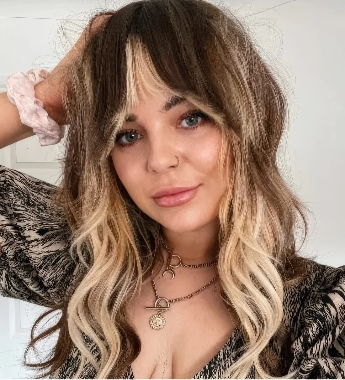 Light brunette hair with blonde highlights and bottleneck bangs to frame the face perfectly.
