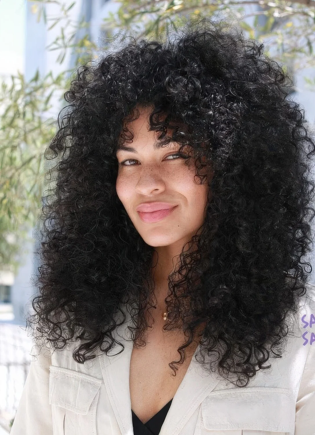 Natural black curls with bottleneck bangs.