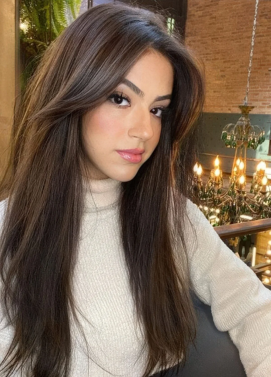 Long dark hair with long curtain bangs to add even more volume to the hairstyle and highlight the face.