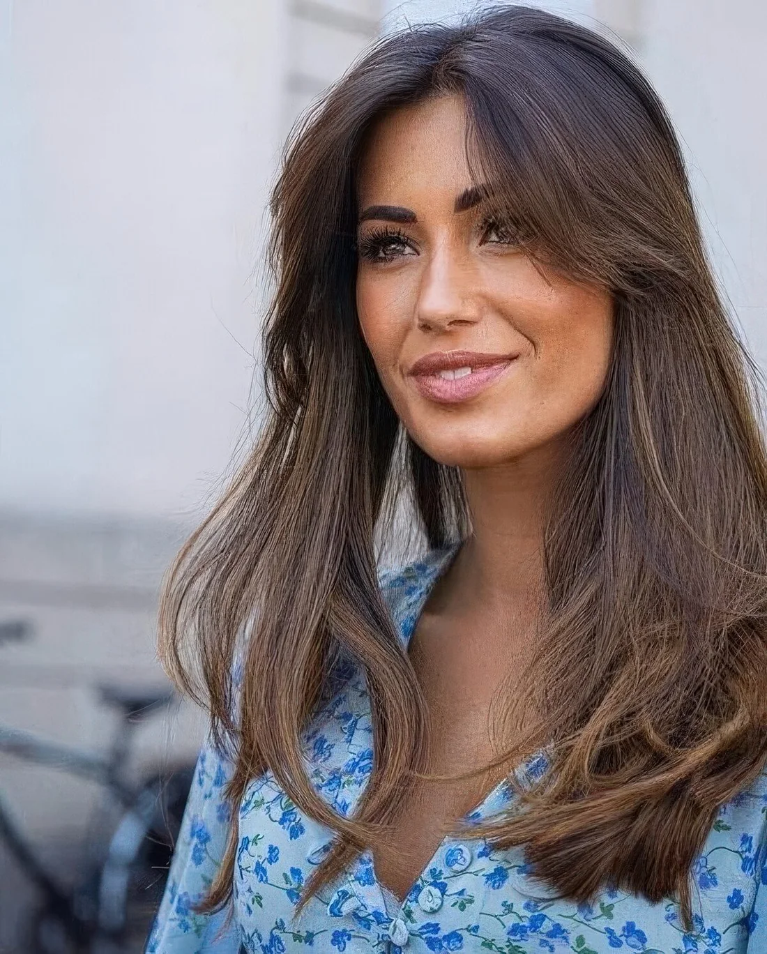 Long dark brunette hair with texture and volume, with short curtain bangs.
