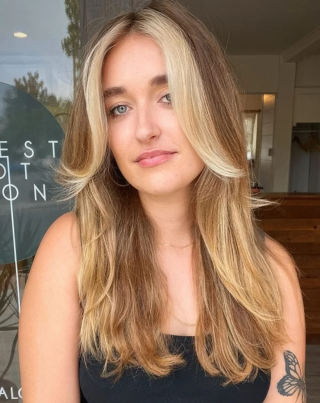 Long light brown hair with blonde highlights and a chunky chin-length money piece.