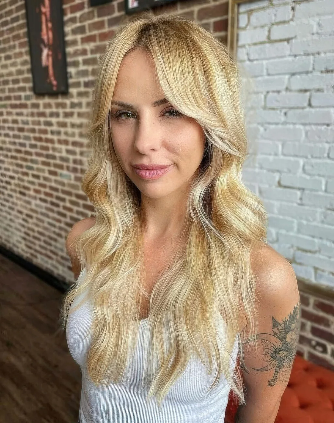 Long blonde hair with shaggy ends and center-parted bangs that are great for framing the face.