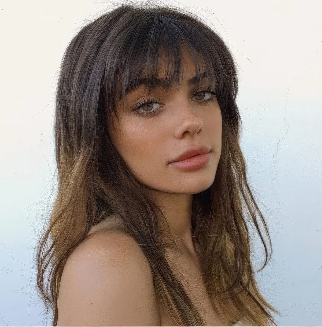 Photo showing ombre hairstyle with wispy bangs, with the hairstyle clearly visible.