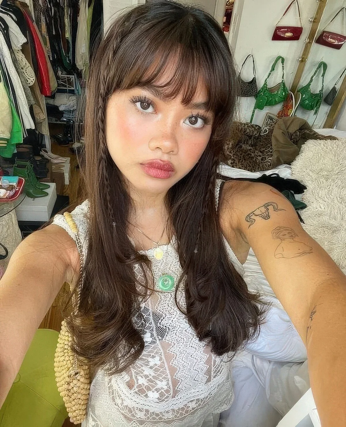 Long dark brown hair cut in layers and with wispy bangs that take off excessive weight off the face.