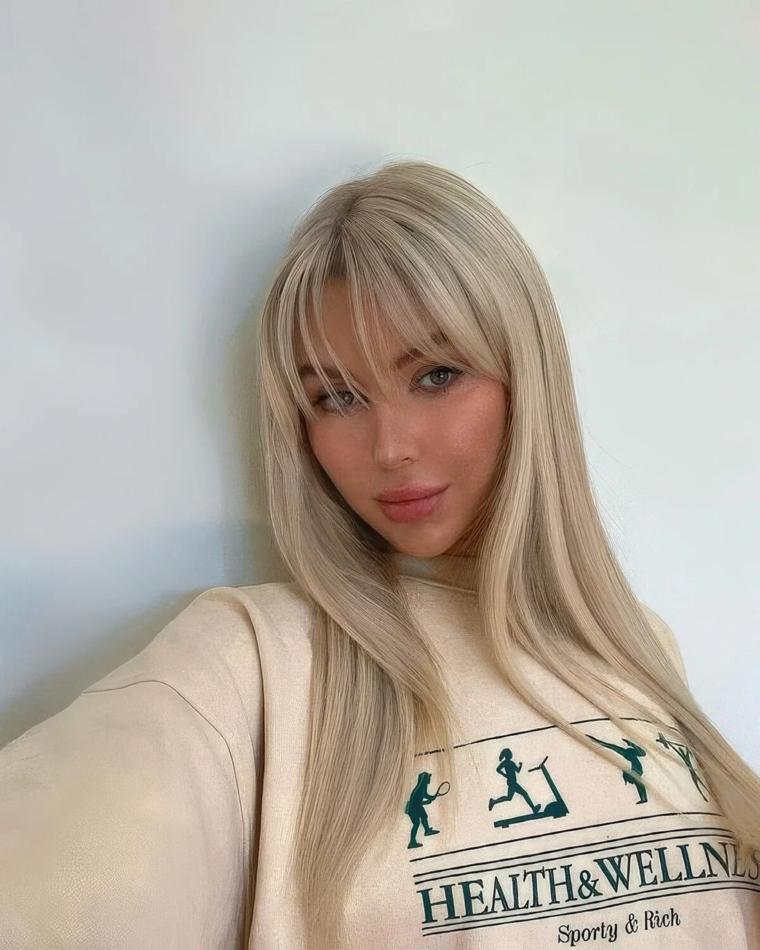 Long icy bloned hair with wispy bangs.