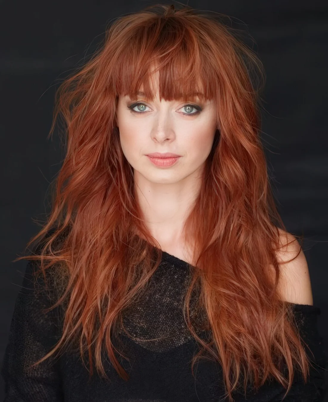 Long cascading shag red hair with a long fringe for a messy and romantic look.