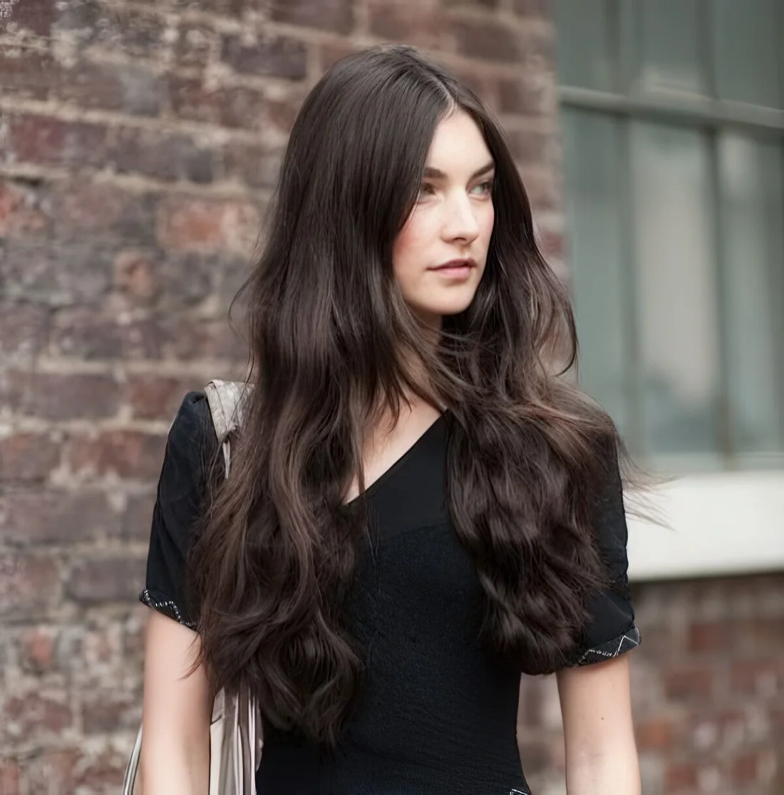 Messy long dark hair with waves and a sleek top for an all natural look.