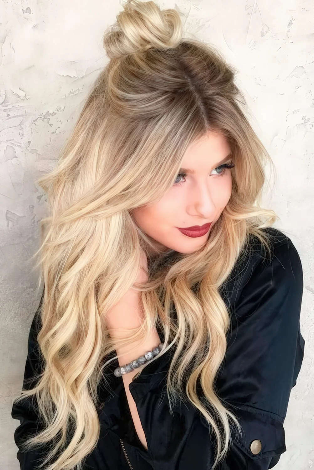 Long layered haircut in icy blonde with a darker root for a dimension.