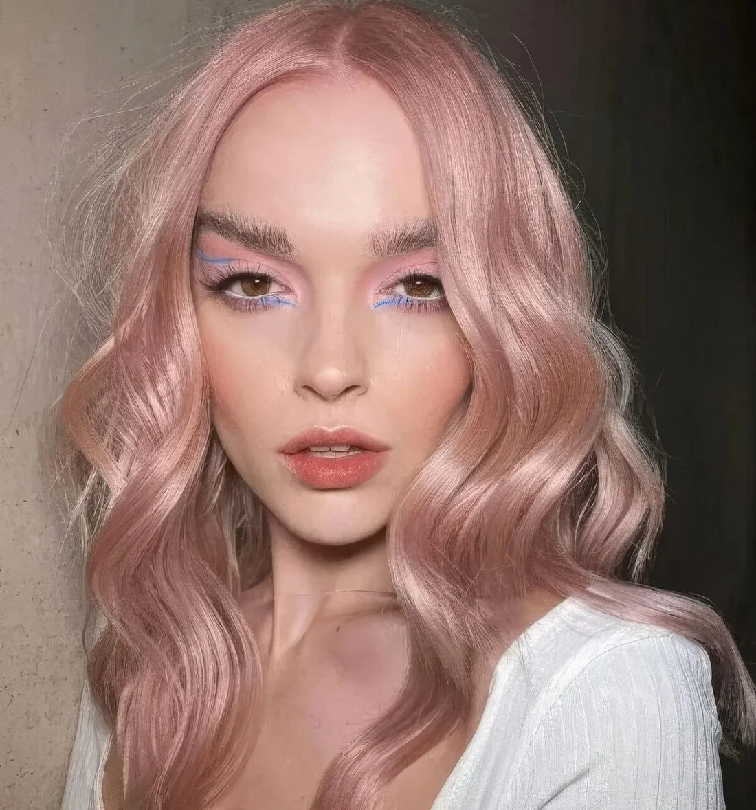 Wavy peachy rose hair with center part.