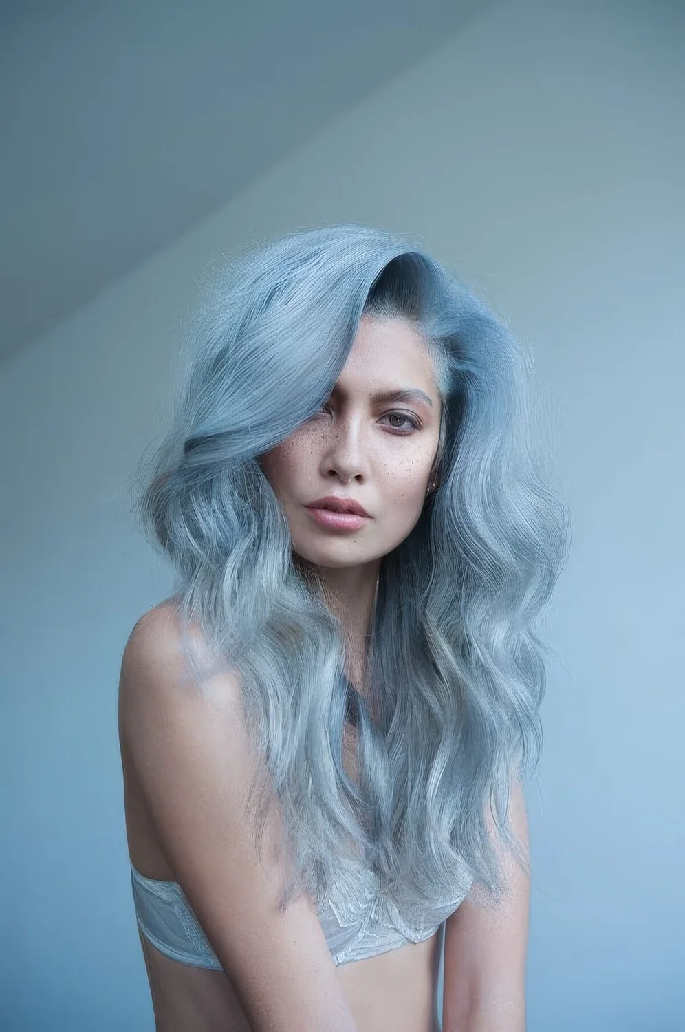 Pastel blue hair with an ombre effect, much volume and waves.