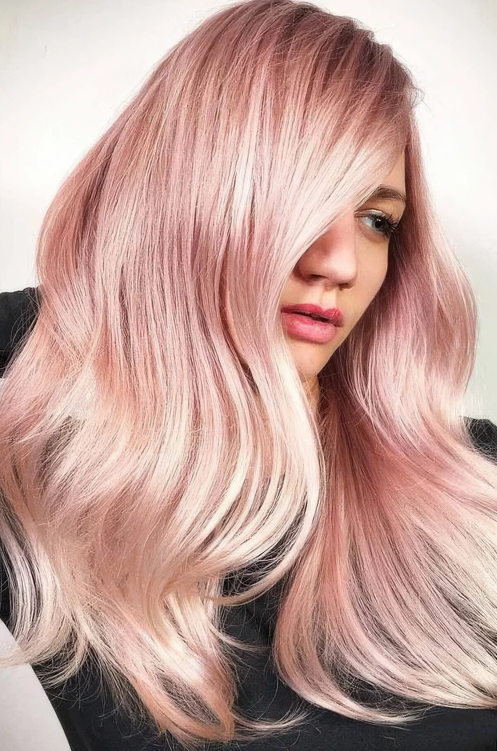 Long and shiny peachy rose gold hair with a bit of waves.