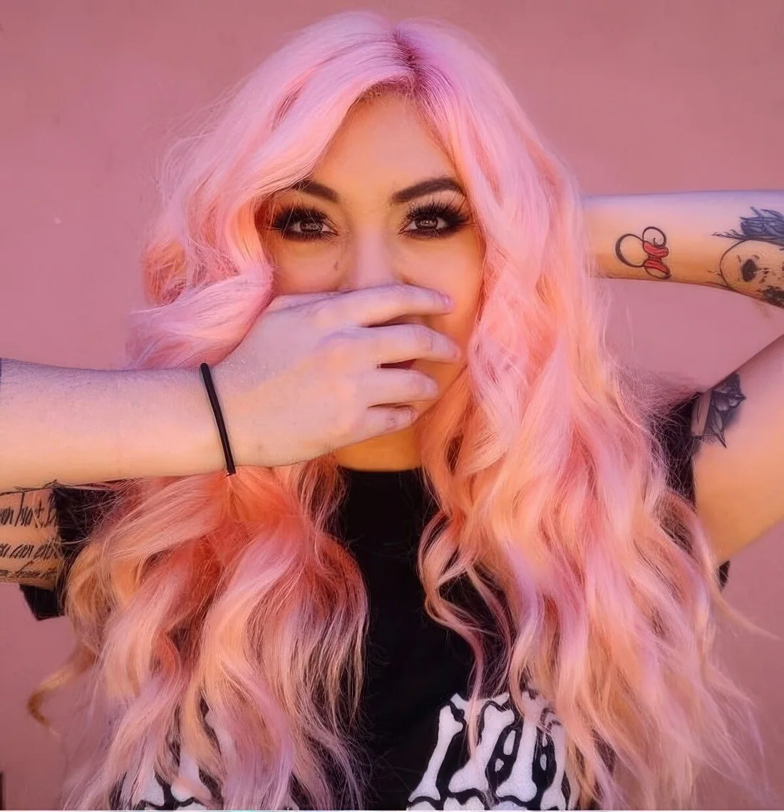 Long and wavy pastel pink hair with side part.