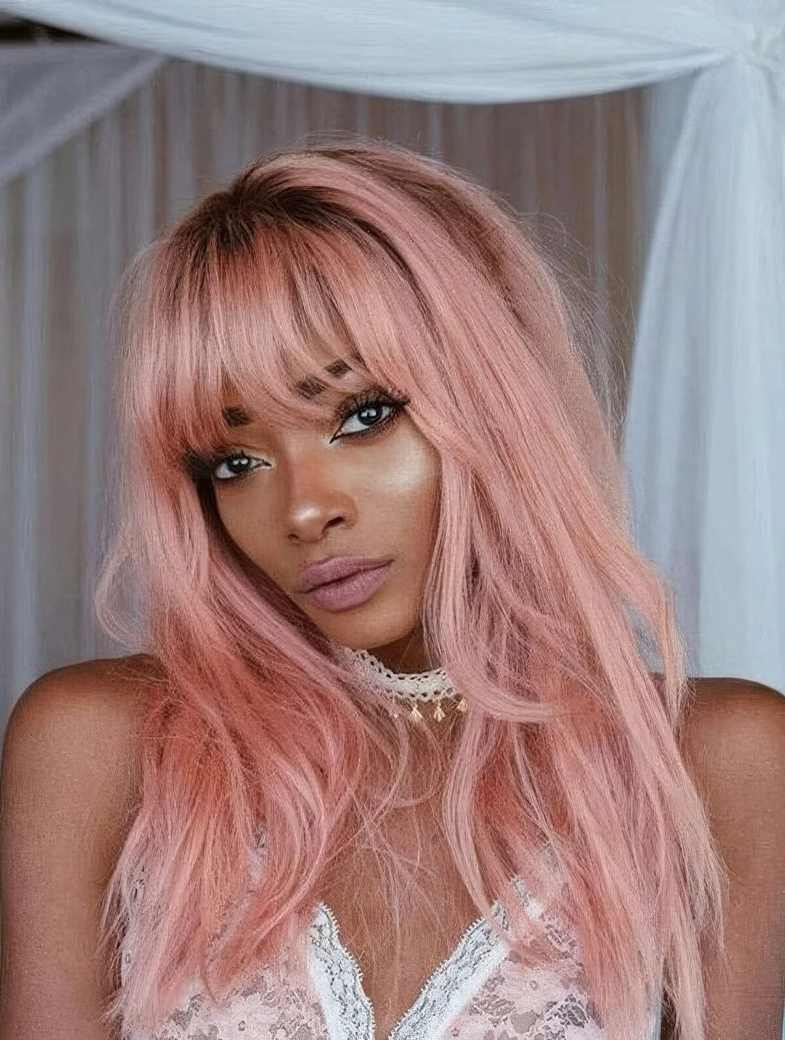 Long pastel pink hair with much texture, with bangs and layers.