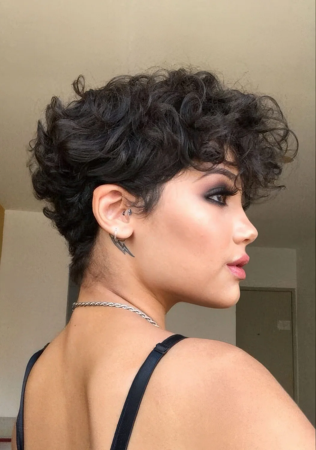 Black wavy pixie with a lot of volume and longer bangs.