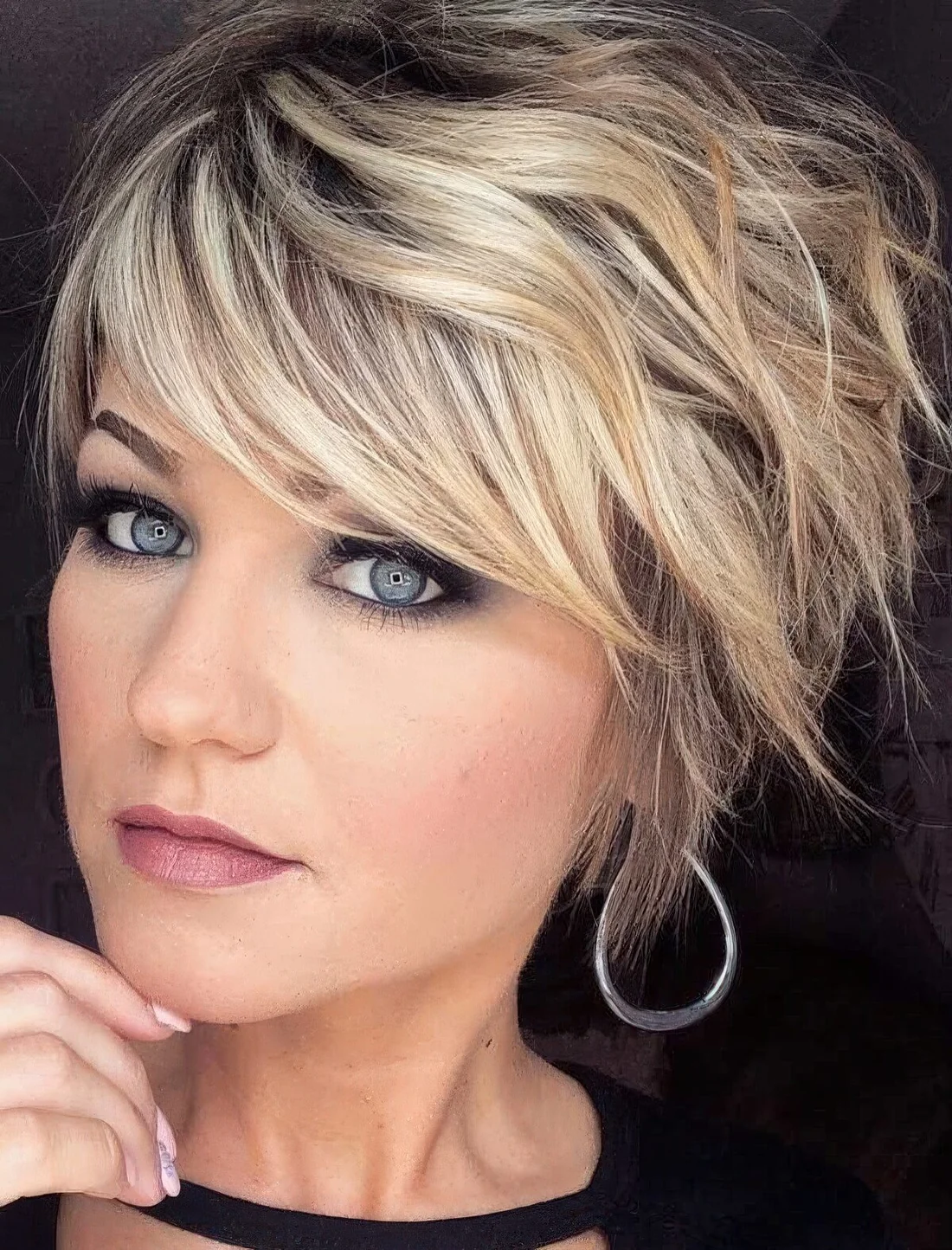 Blonde layered and shaggy pixie haircut with a darker root.