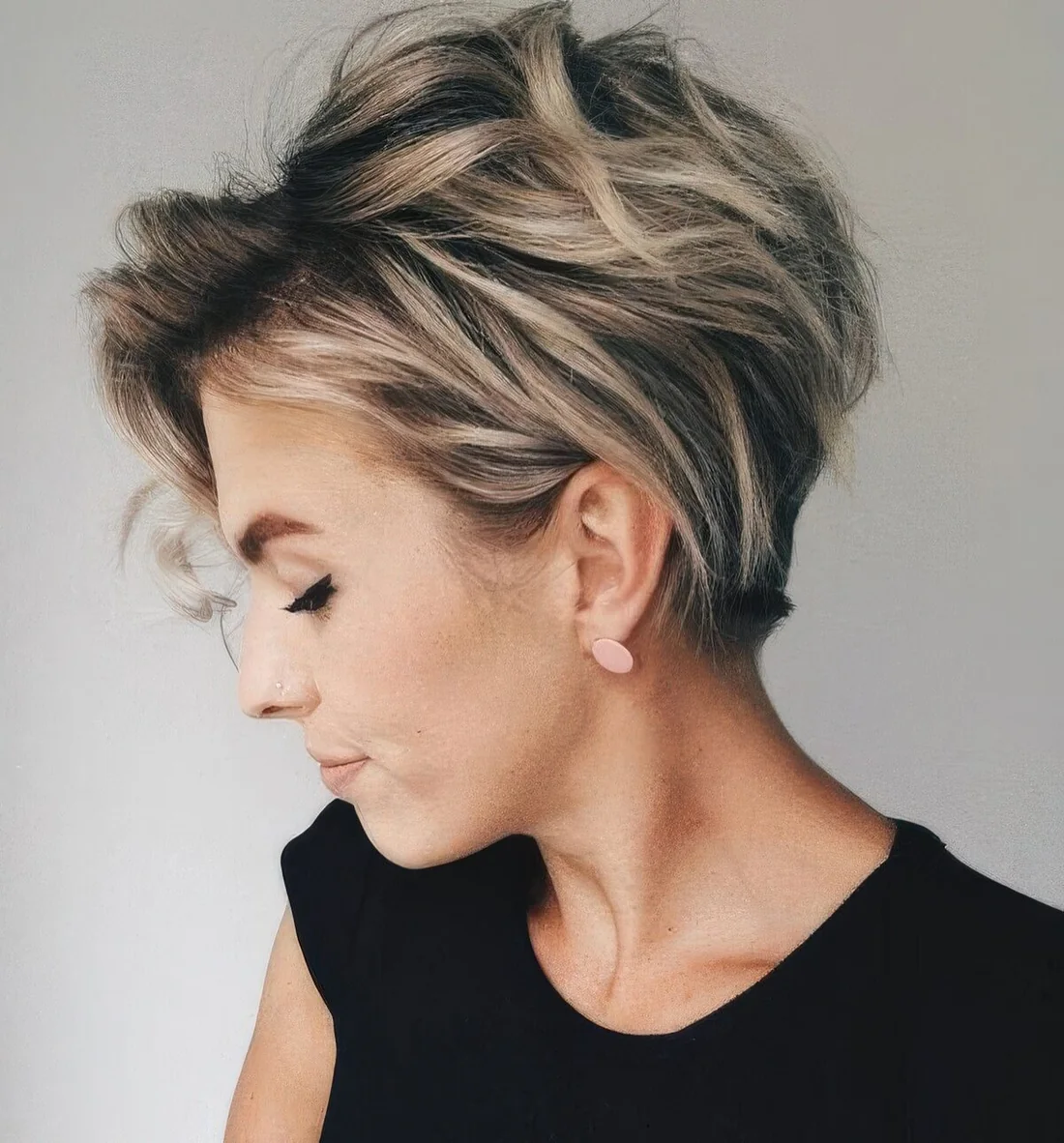 Long pixie with blonde balayage and a darker root.