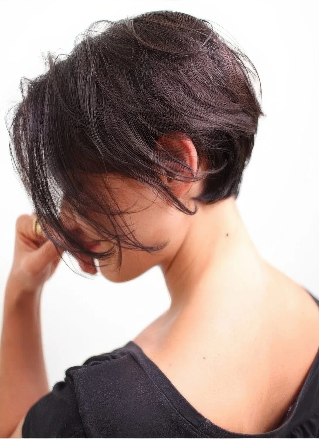 Dark brown textural bixie with long bangs and a lot of volume.