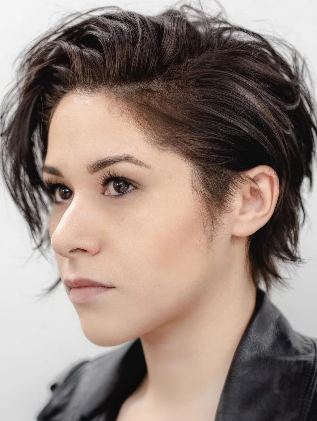 Messy pixie haircut with layers and a long fringe play well with the messy look and give an almost carefree attitude.