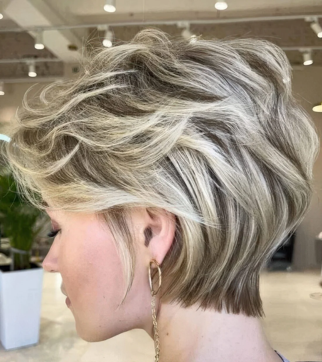 Short and feminine pixie haircut with blonde balayage.