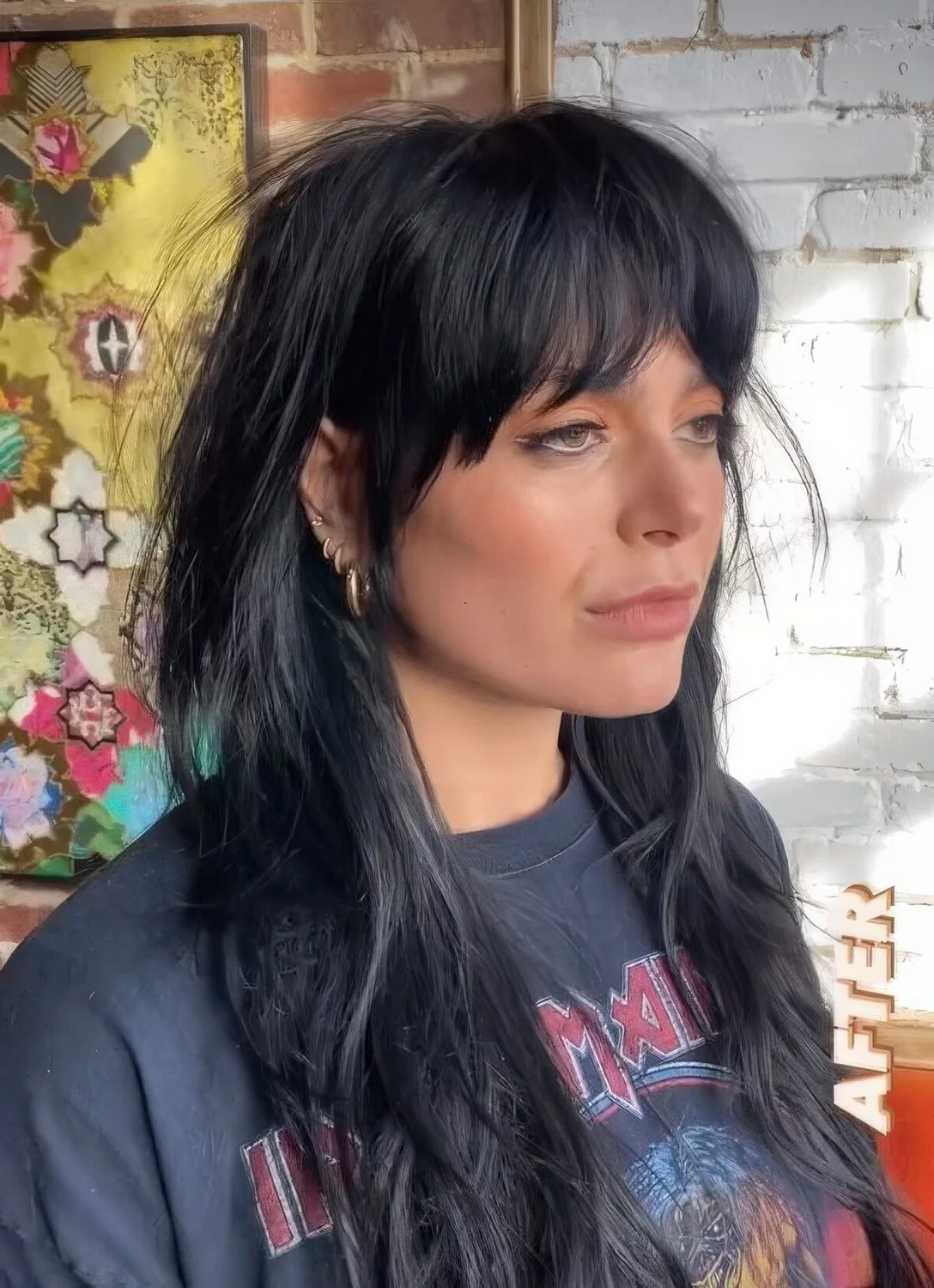 Black long wolf haircut with bottleneck bangs and waves down.