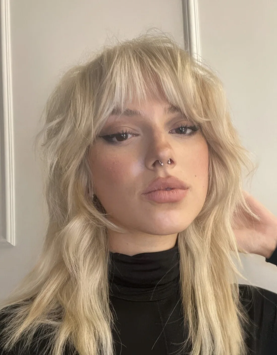 Blonde wolf cut with curtain bangs and layers.
