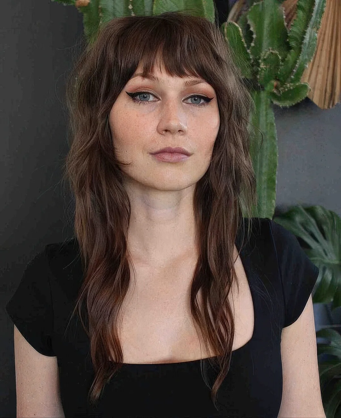 Brunette wolf cut with bangs and waves down.