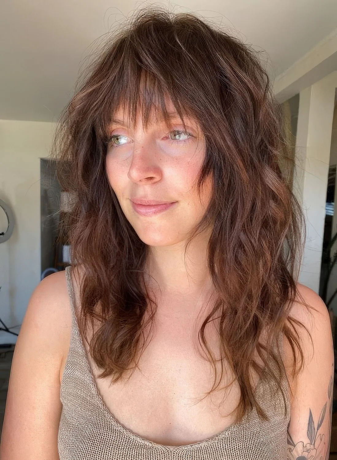 Dark brunette long wolf cut with wispy bangs and messy waves.