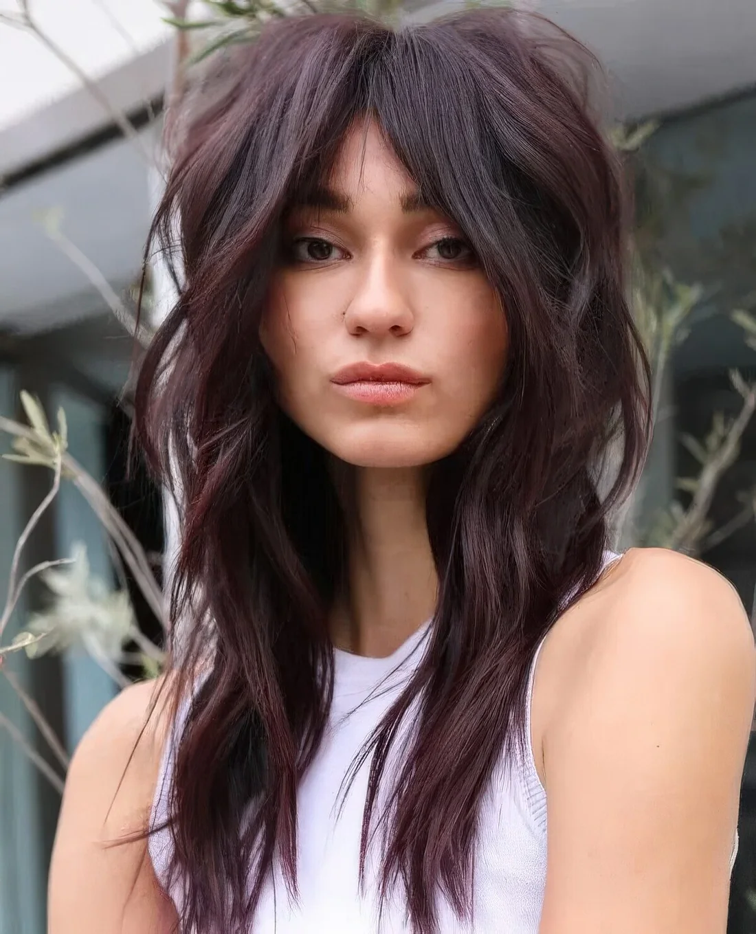 Deep purple long wolf cut with volume only on top and waves plus bottleneck bangs.