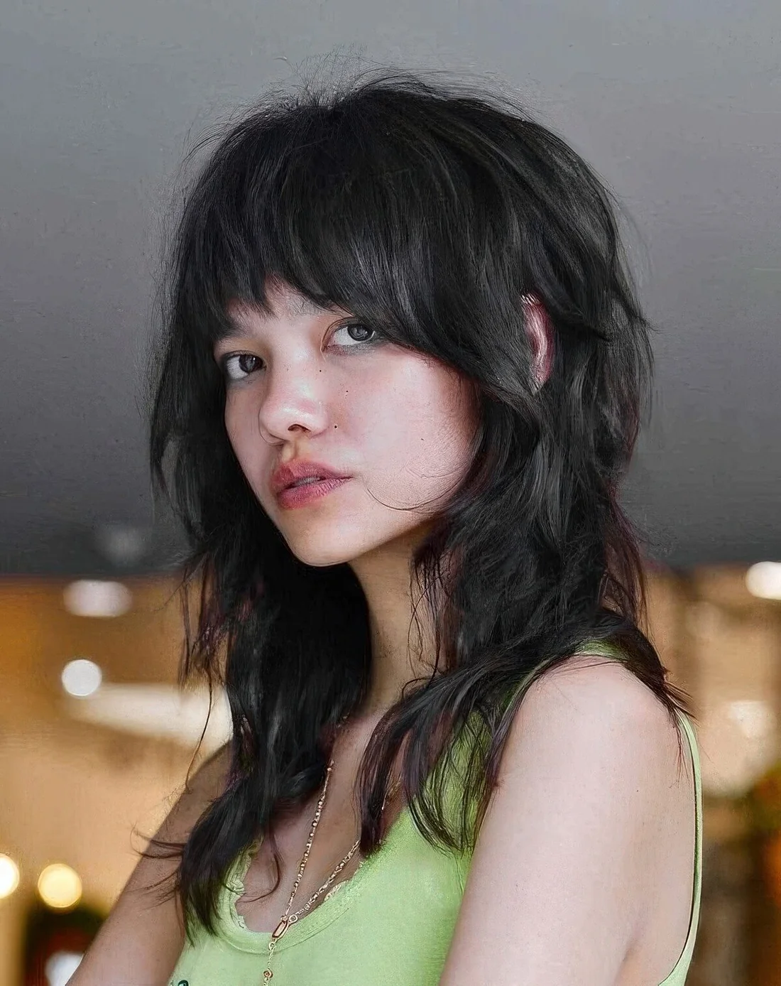 Shaggy wolf cut in black, with bangs and messy waves.