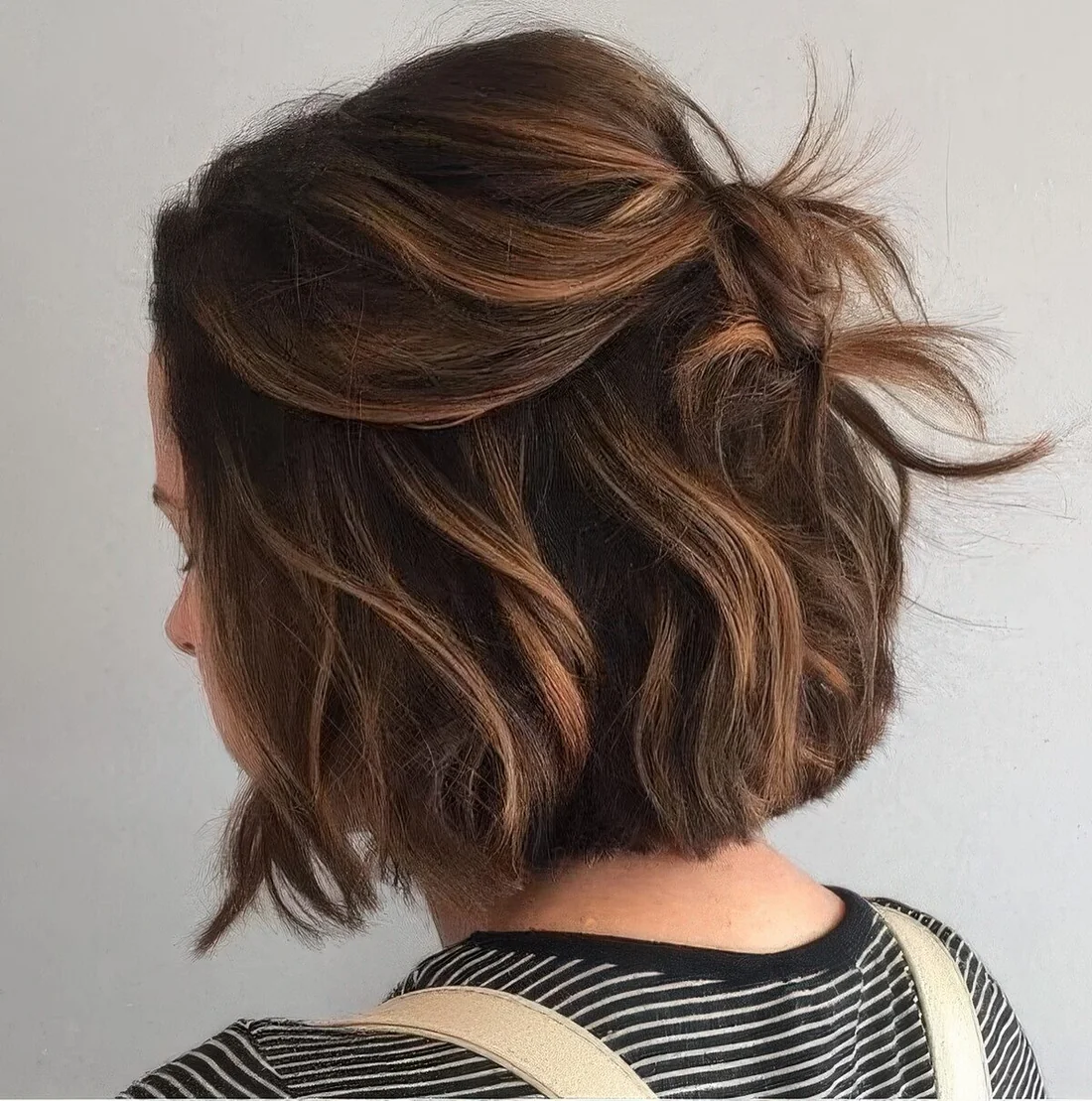 Black bob done with caramel balayage, with a lot of volume, waves.