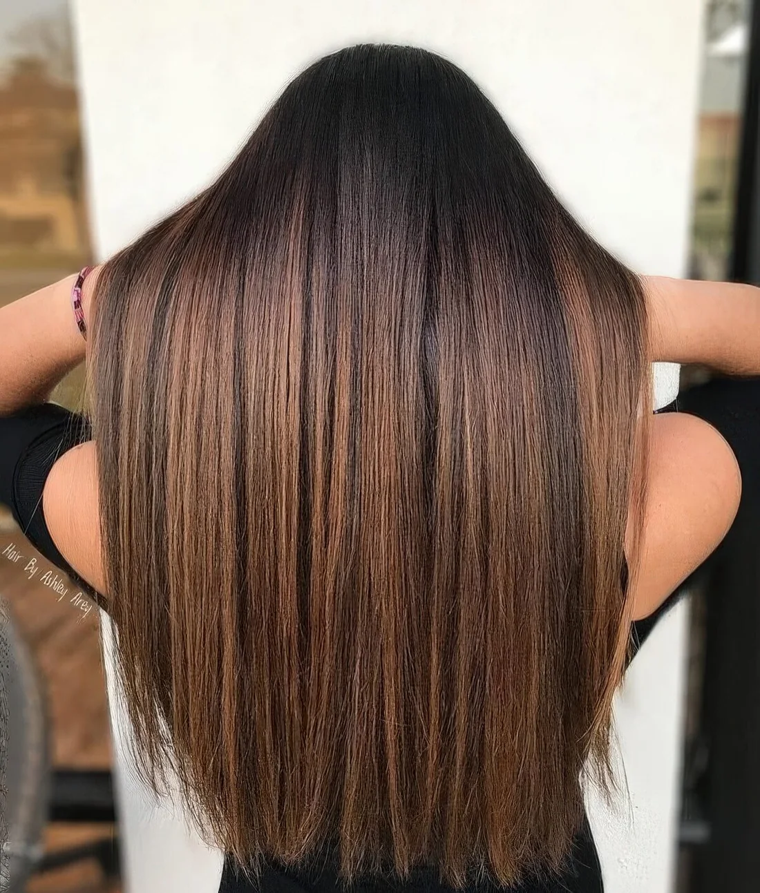 Black hair with gorgeous caramel highlights that give eye catchiness and a bold touch to the look with this contrast.