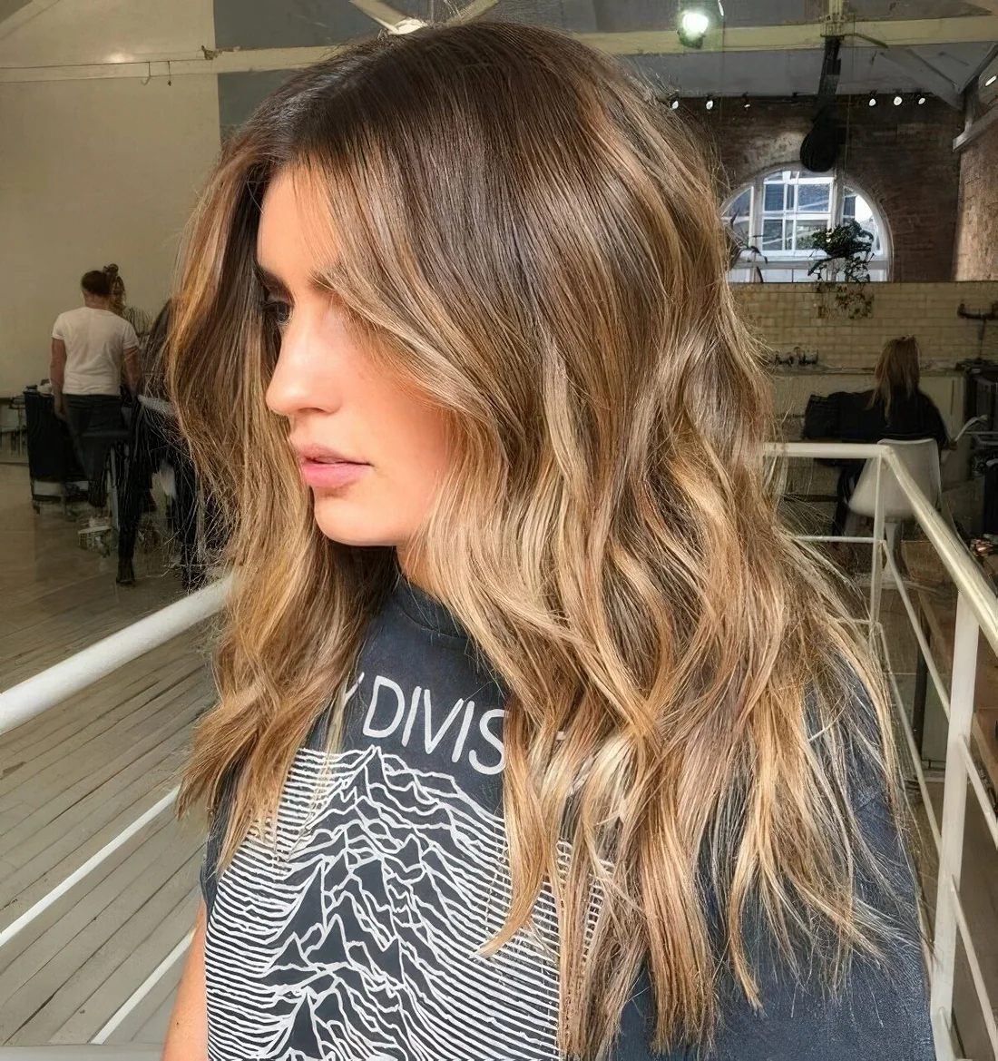 Brown hair with a pop of honey blonde placed to frame the face and with an angled scheme.