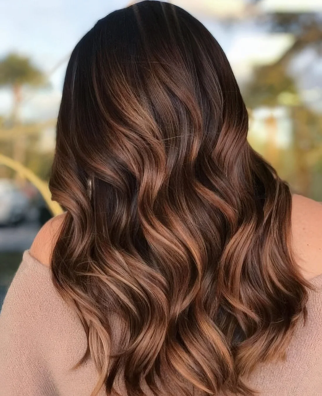 Dark brunette hair with waves and gorgeous caramel balayage.